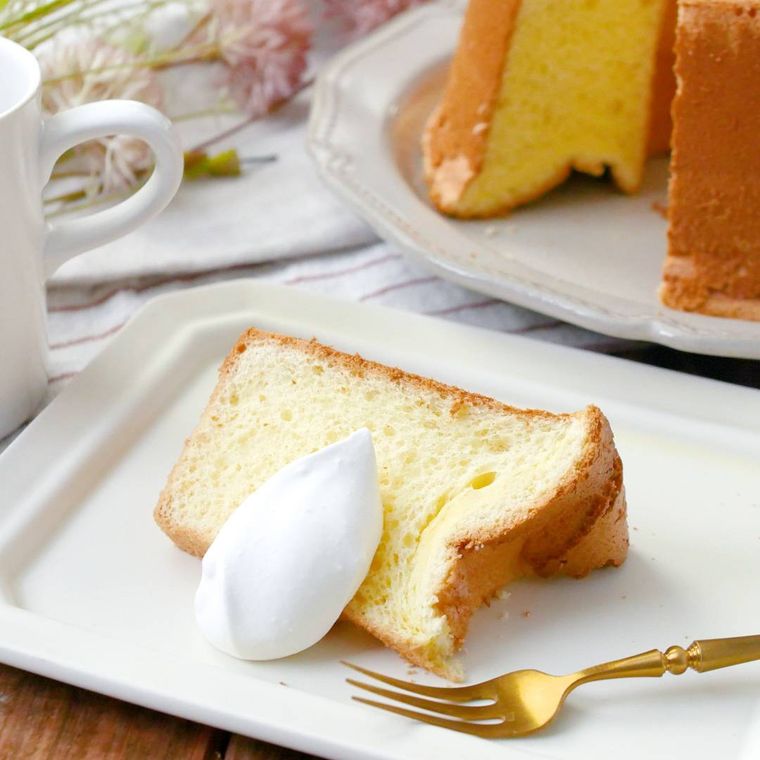 クリームが添えられているシフォンケーキが皿に盛り付けられているところ