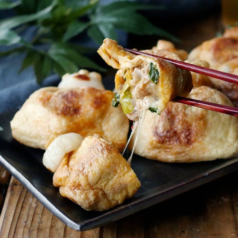 黒い皿にのった豚こま肉とキムチのチーズ巾着