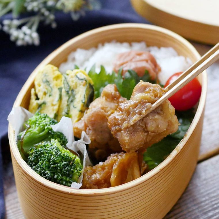 唐揚げ、ブロッコリー、卵焼き、トマト、ごはんがわっぱのお弁当に詰められている