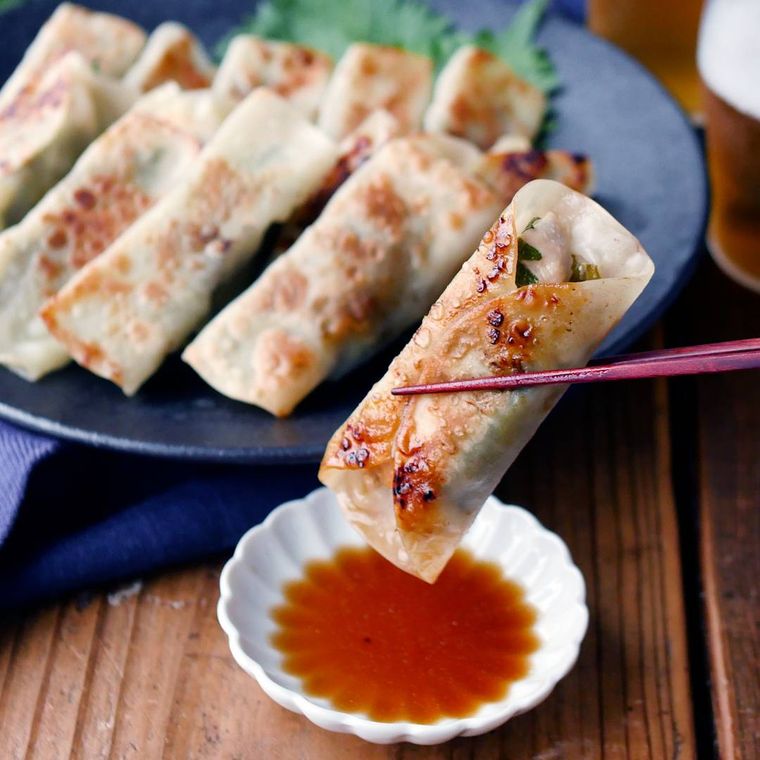 皿に盛りつけられた鶏むね肉の梅しそ棒餃子を、箸でつまんだ様子