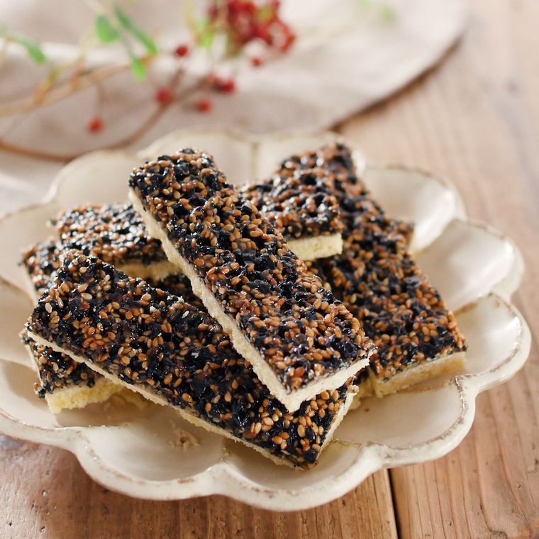 花びら形の白い皿に盛りつけられた、白と黒いりごまのフロランタン