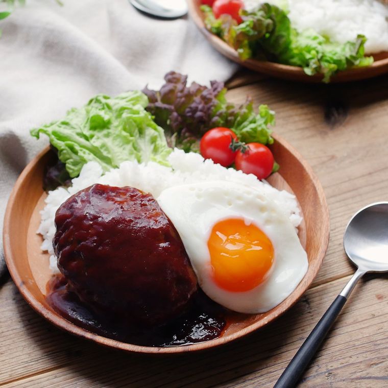 木の丸いお皿に盛られたごはん、ハンバーグ、目玉焼き、サラダ菜、ミニトマト
