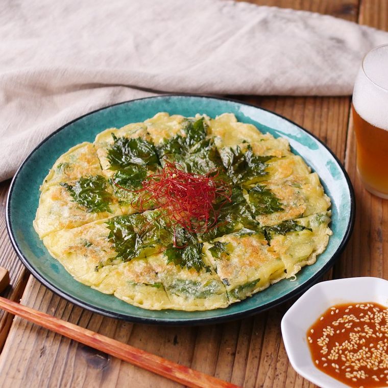 青色の丸皿に盛られた大葉とチーズのチヂミ