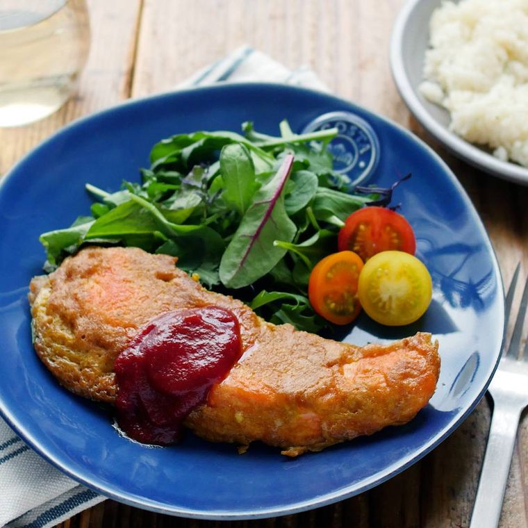青い皿に盛られている生鮭のカレー粉ピカタ
