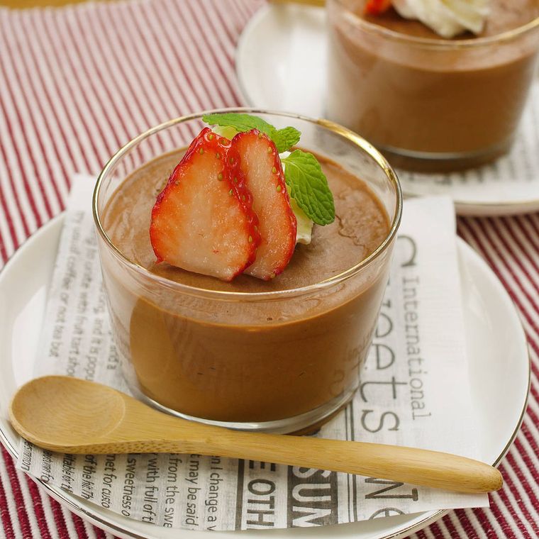 白い皿にのせた、グラス入りのふわふわチョコレートムース