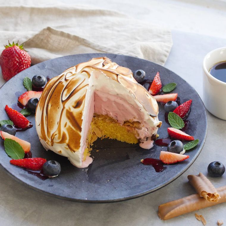 黒い皿にフルーツと盛られた、ベイクドアラスカ