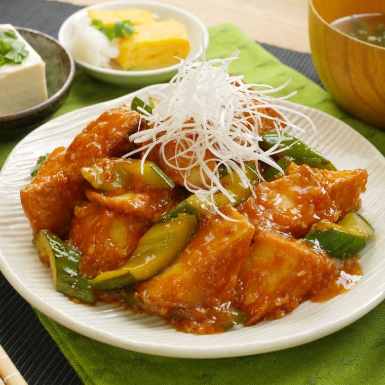 白い皿に盛りつけられた厚揚げときゅうりのチリソース炒め