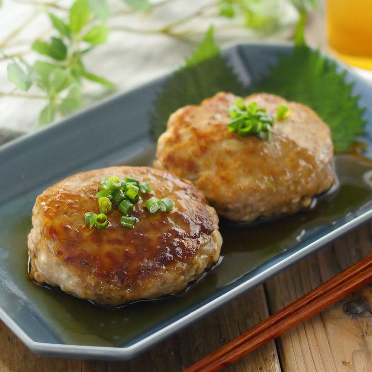 青い角皿に盛りつけられた合い挽き肉と豆腐のハンバーグ
