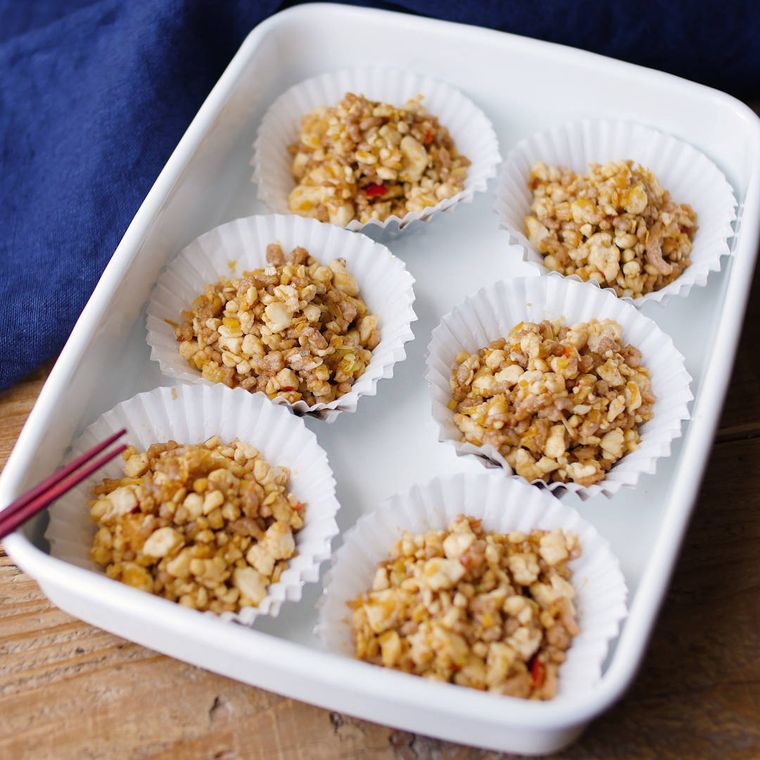 ホーローの保存容器の中に、カップに小分けされて並ぶ汁なしパラパラ麻婆豆腐