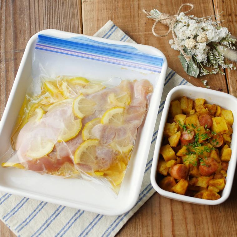 琺瑯容器に入れた、保存袋で漬けた鶏胸肉のレモンオリーブオイル漬けとカレーウインナーポテト