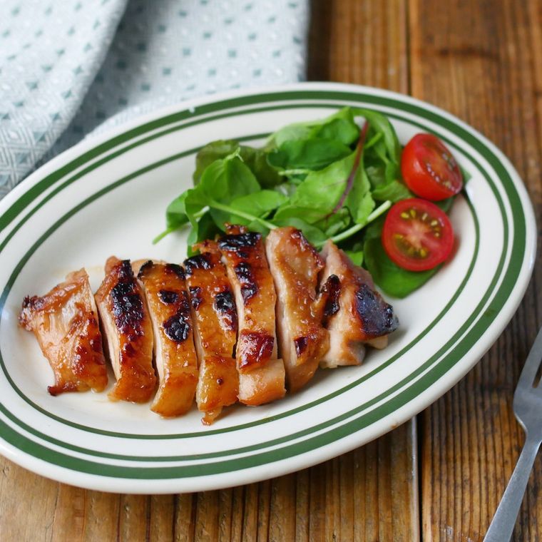 ベビーリーフとミニトマトを添えたタイ風焼き鳥ガイヤーン