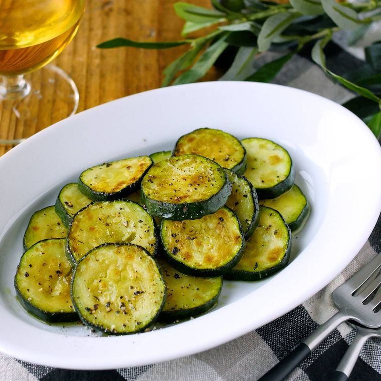 ジューシーなズッキーニのレモンマリネが楕円形の白い洋食器に盛り付けられているところ