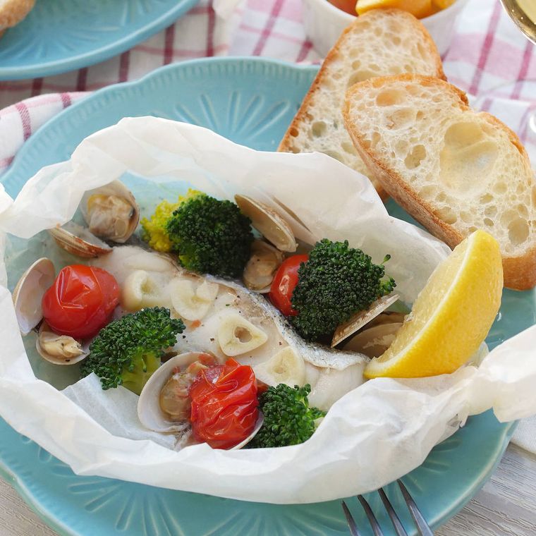 クッキングシートで包んで電子レンジで作ったたらのアクアパッツァが青い器に盛り付けられているところ