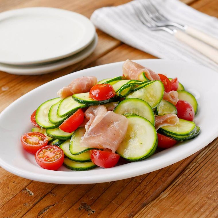 白い皿にのった、ズッキーニとミニトマトのマリネ