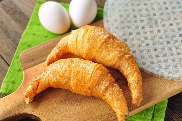 ライスペーパーとライスペーパークロワッサンをのせたカッティングボードの奥に卵が置いてある