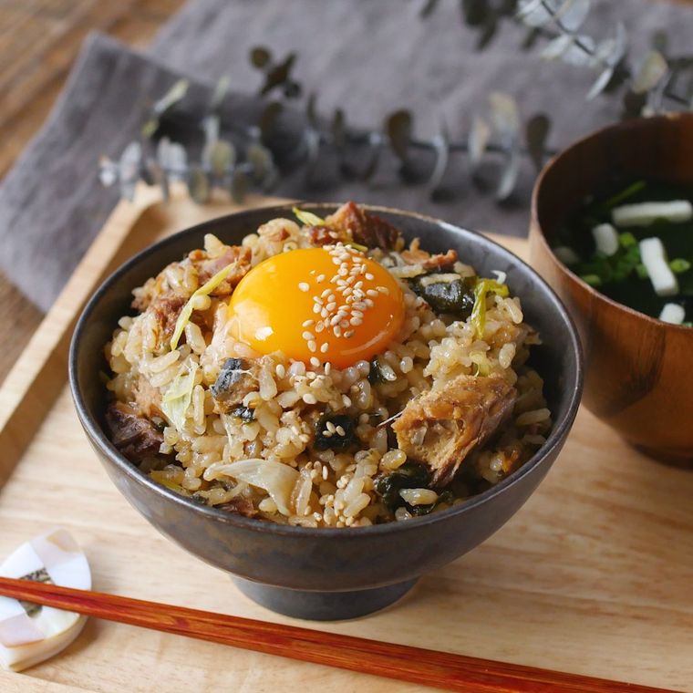 黒い茶碗に盛り付けてあるさば味噌缶とバターの炊き込みごはん