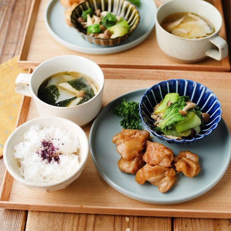 青い皿に盛られているレンジで鶏のから揚げとトレイの上にあるごはんなど