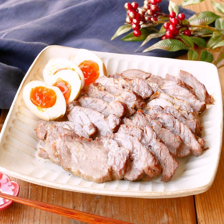 ベージュの皿に盛られている豚肩ロース肉の煮豚とゆで卵など