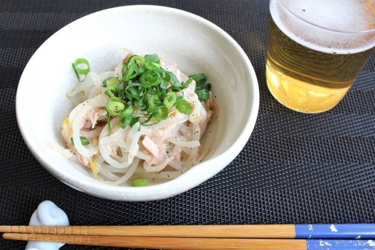 白い器に万能ねぎをトッピングした無限もやしが盛られ、ビールと箸が置かれている様子