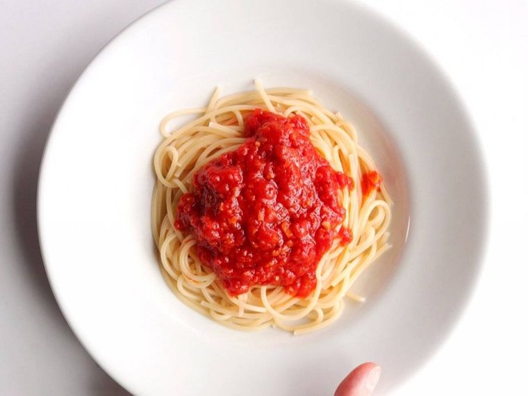 白いプレートに盛り付けたトマトソースパスタ