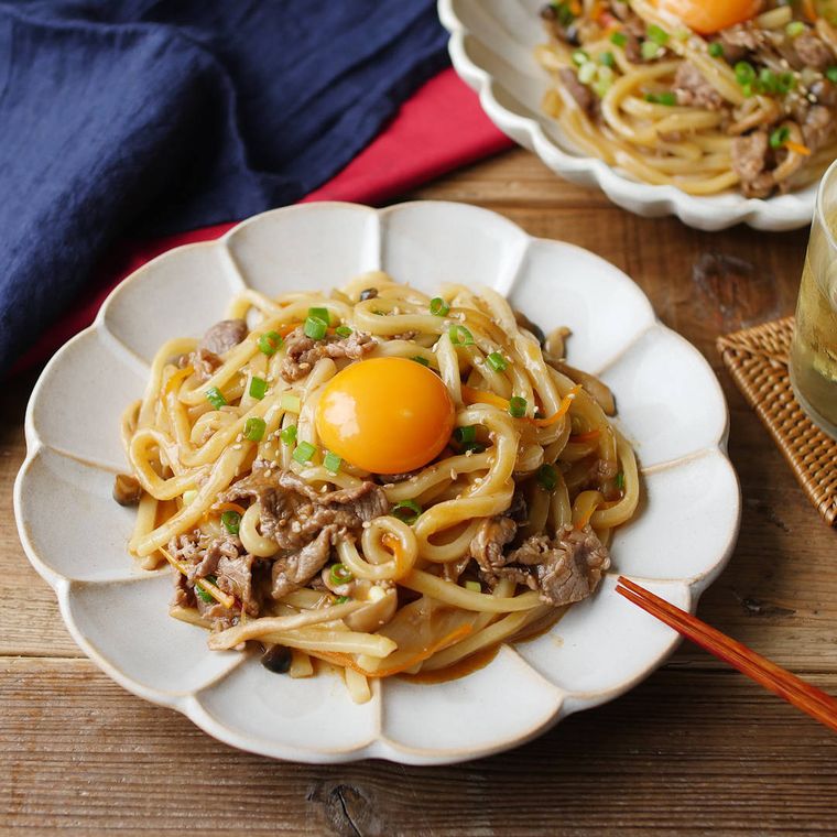 牛薄切り肉と野菜を使ったプルコギうどんが白い円形の洋食器に盛り付けられているところ