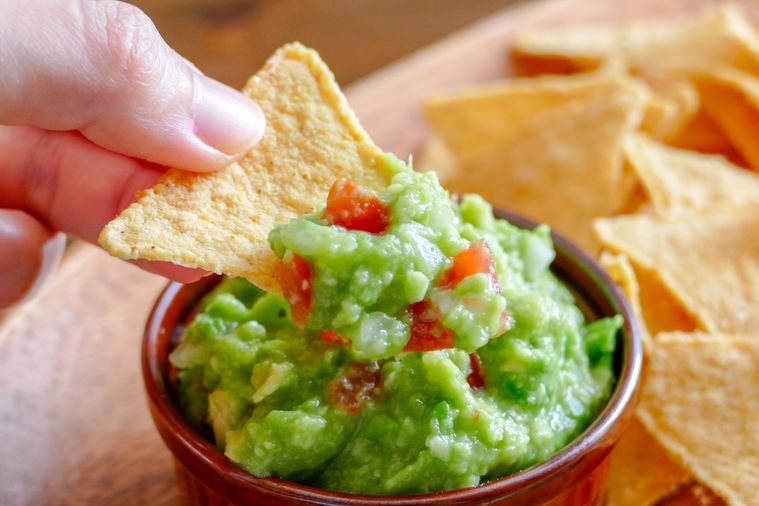 トルティーヤチップスをワカモレにディップする様子