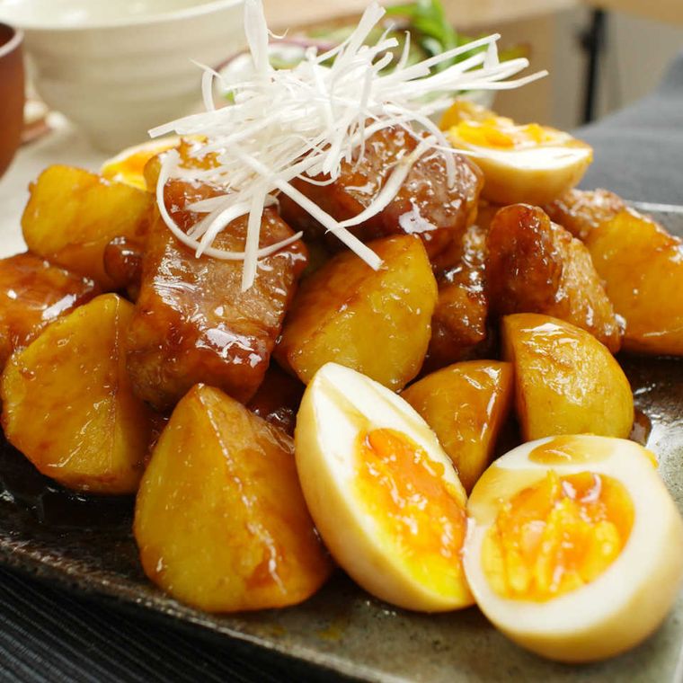 黒い皿に盛られたゴロゴロじゃがたまの黒酢酢豚