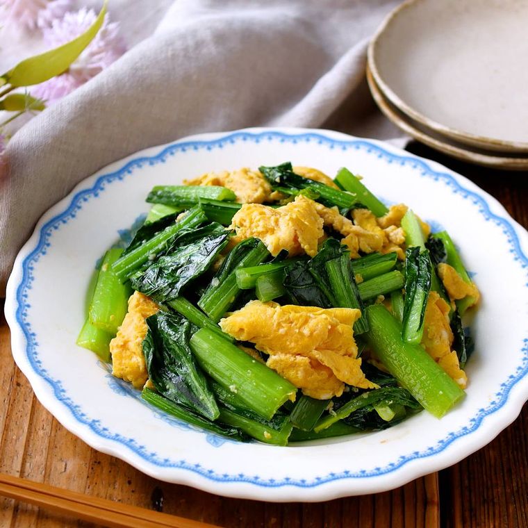 柄つきの皿に盛られた小松菜と卵の中華炒め