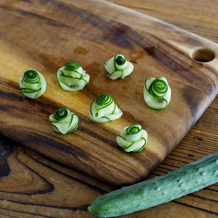 木のカッティングボードに置かれたきゅうりの飾り切り