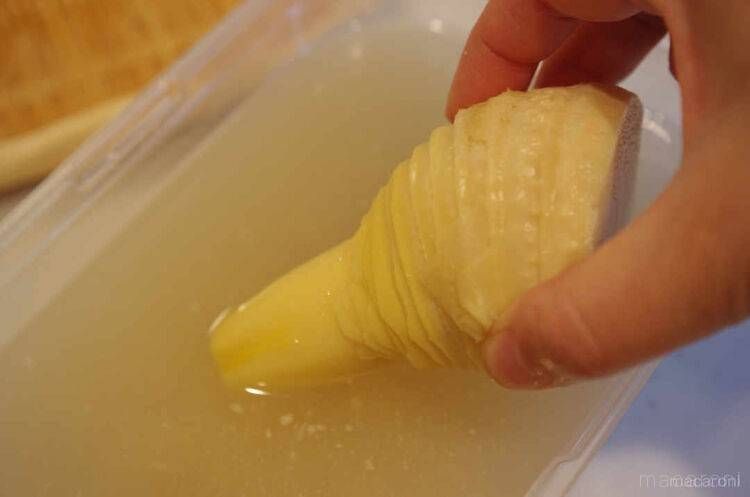 たけのこを水を張った保存容器に入れる様子