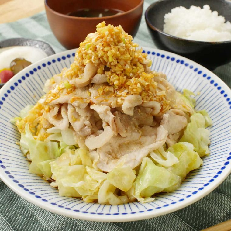 青い模様が入った皿に盛られたリ辛ねぎだれの豚しゃぶキャベツピ