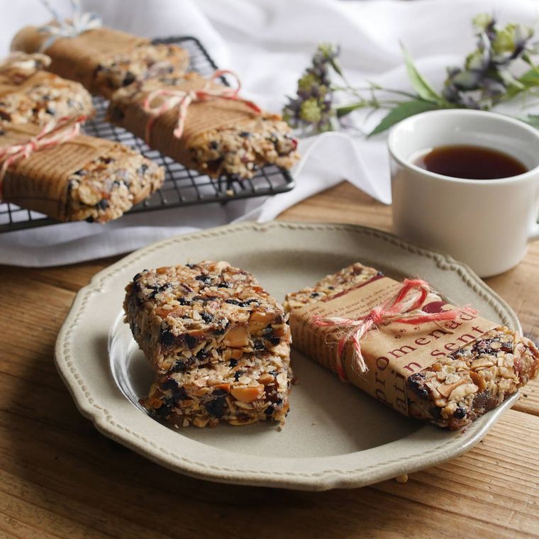 ケーキクーラーとベージュの皿に盛り付けられた、ラッピングされたグラノーラバー