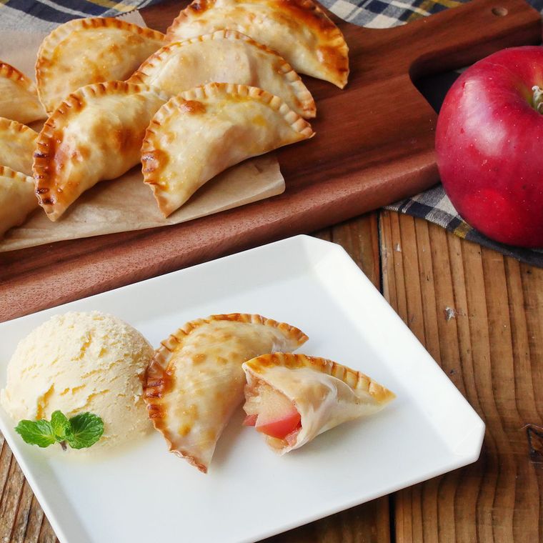 木のボードと白く四角い皿にアイスクリームとともに盛られたアップルパイ