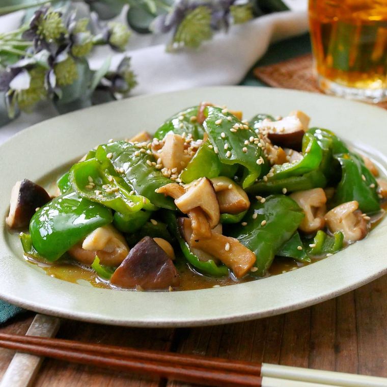 白いお皿にしいたけとピーマンの炒めものが盛られている