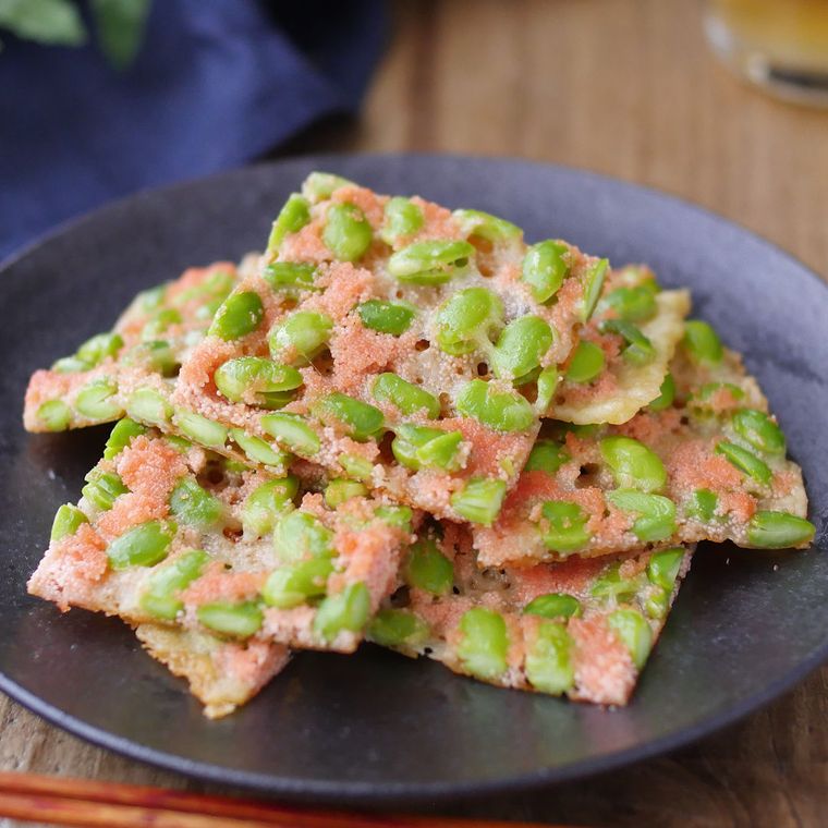 黒い皿に盛り付けられた明太枝豆チーズせんべい