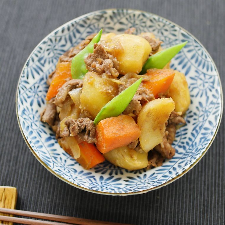 柄つきの皿に盛られた牛肉の肉じゃが