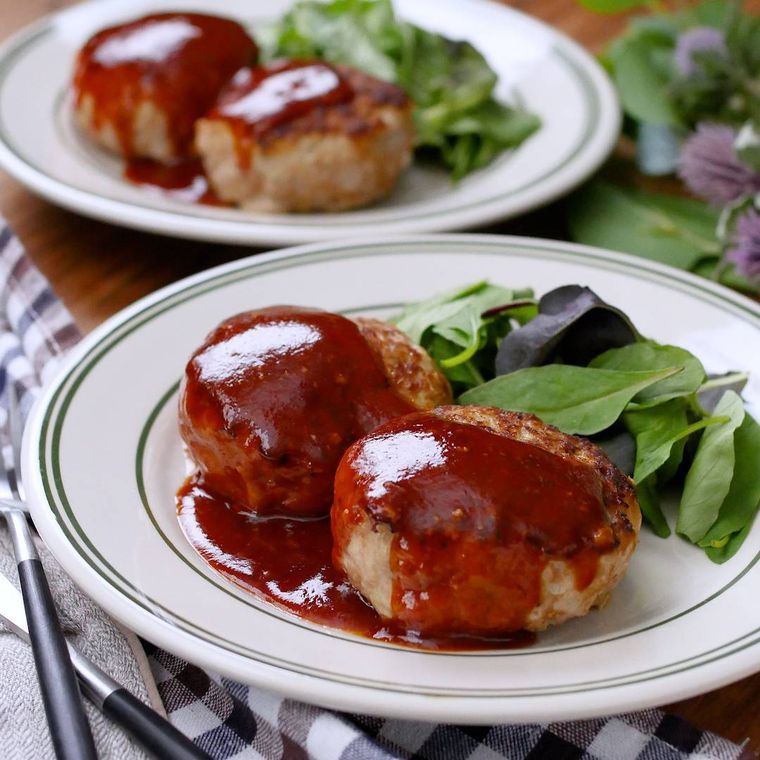 緑の縁の洋皿に盛ったハンバーグ