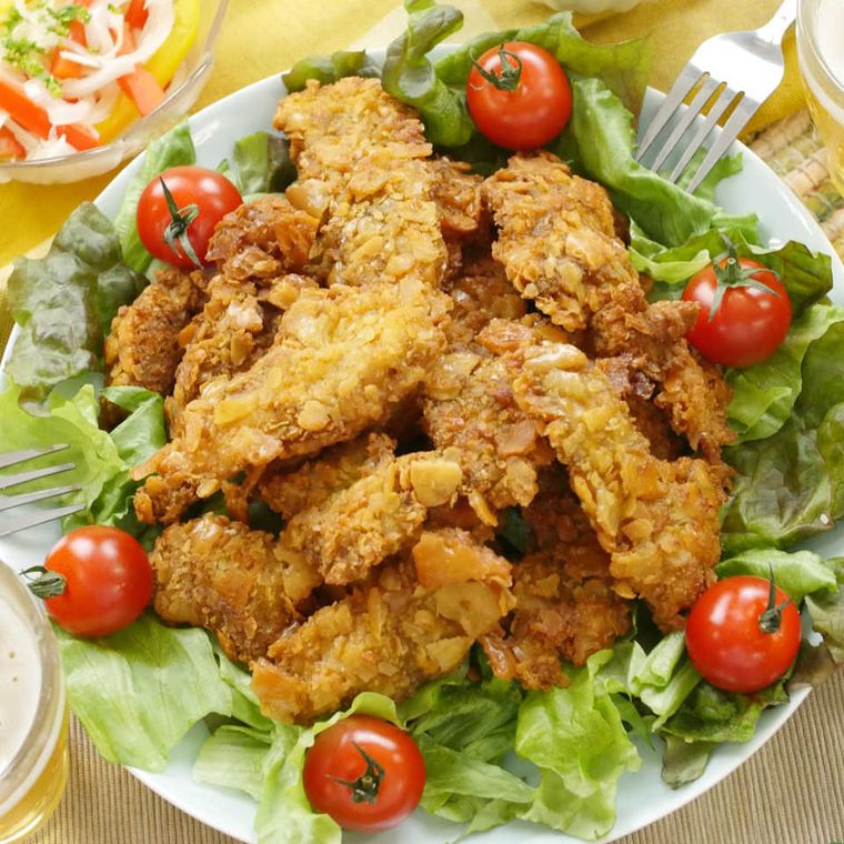 皿に盛られたさくさくフライドチキンに野菜が添えてある様子