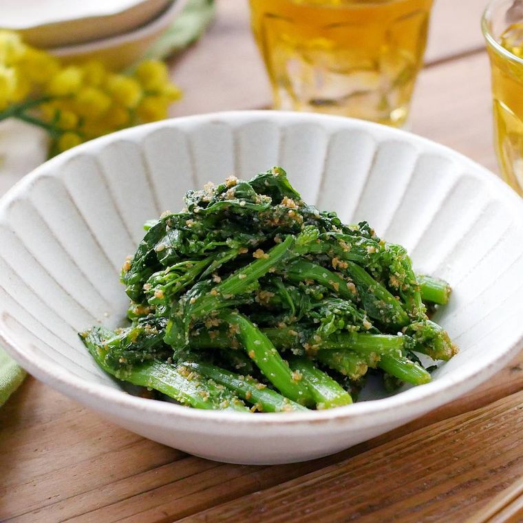 菜の花のごま和えが白い皿に盛り付けられているところ