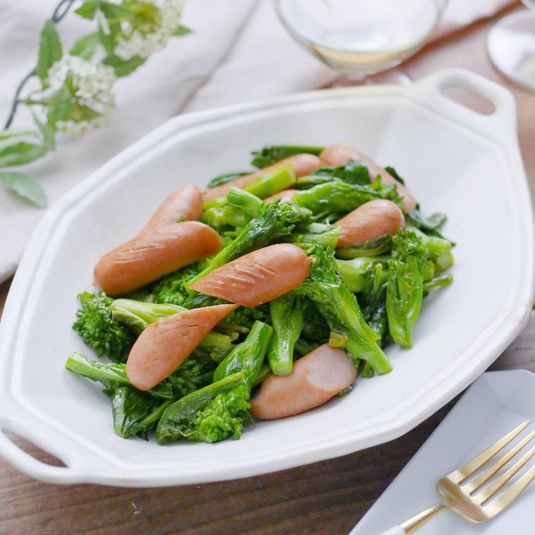 菜の花とウインナーのマヨしょうゆ炒めが白い皿に入っているところ