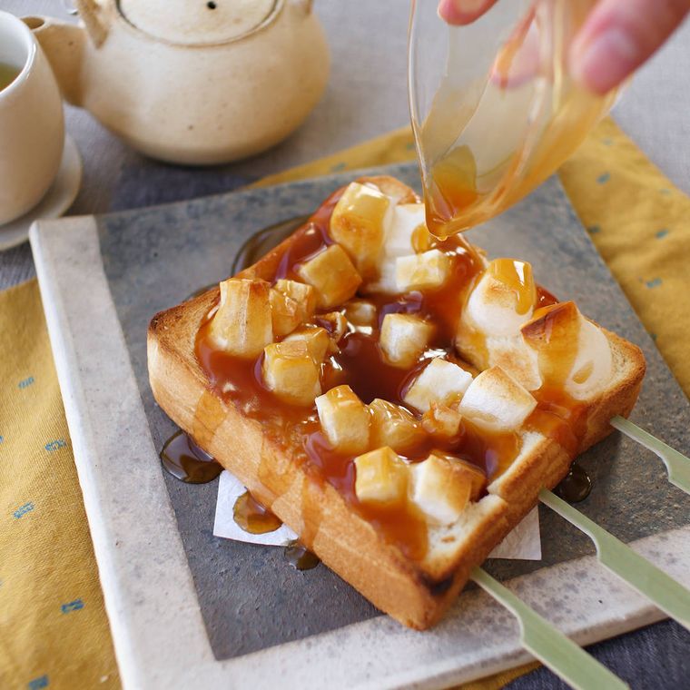 スクエア型の皿にのせられたみたらしトーストにみたらしたれをかけている様子