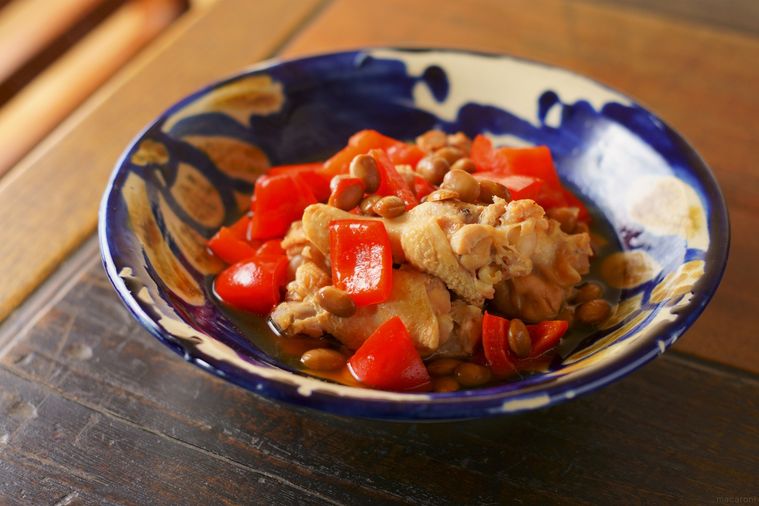 青い皿に盛られた、赤パプリカと鶏手羽元のアドボ