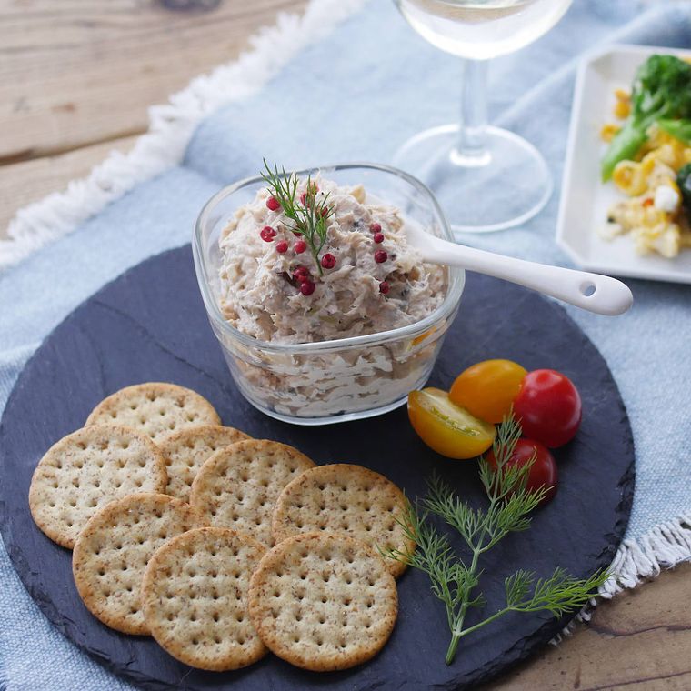 黒い皿にサーモンのチーズリエットとクラッカーが盛られている様子