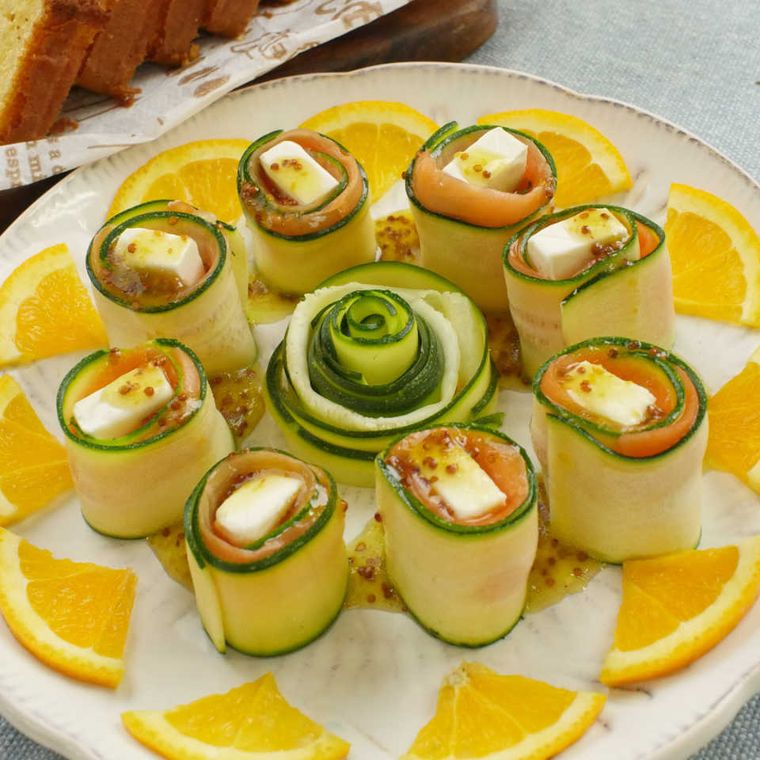 皿に盛り付けられたサーモンのズッキーニ巻きサラダ