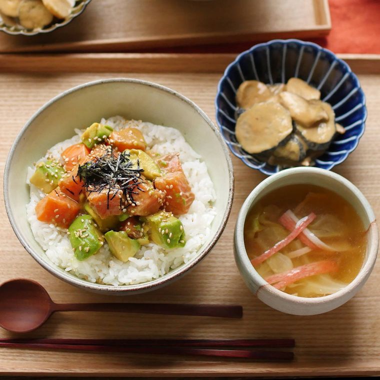 おぼんの上にのっているサーモンとアボカドのピリ辛漬け丼定食