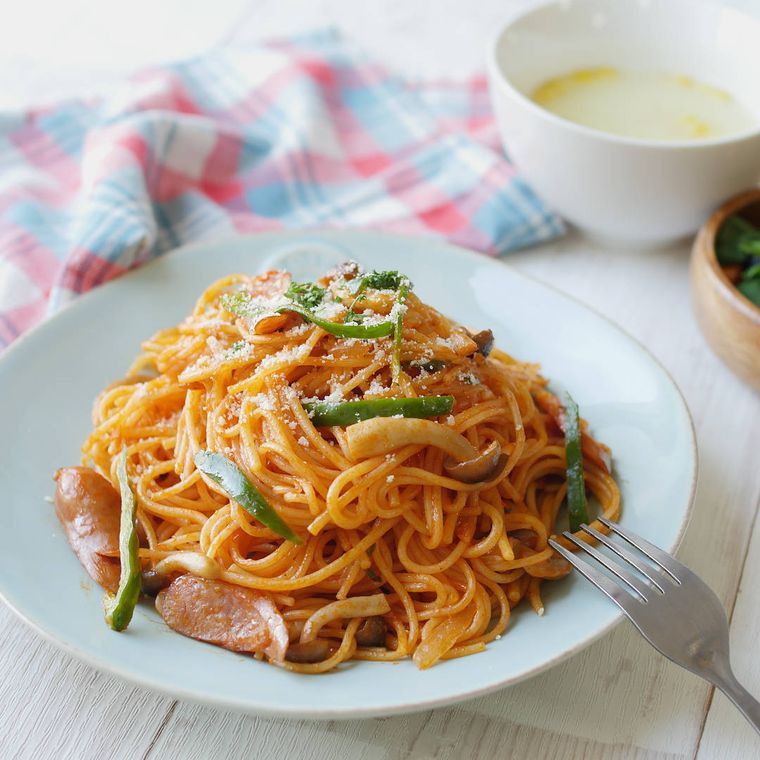 具沢山ナポリタンを盛り付けた薄い水色のプレートに、銀色のフォークがかけられている様子