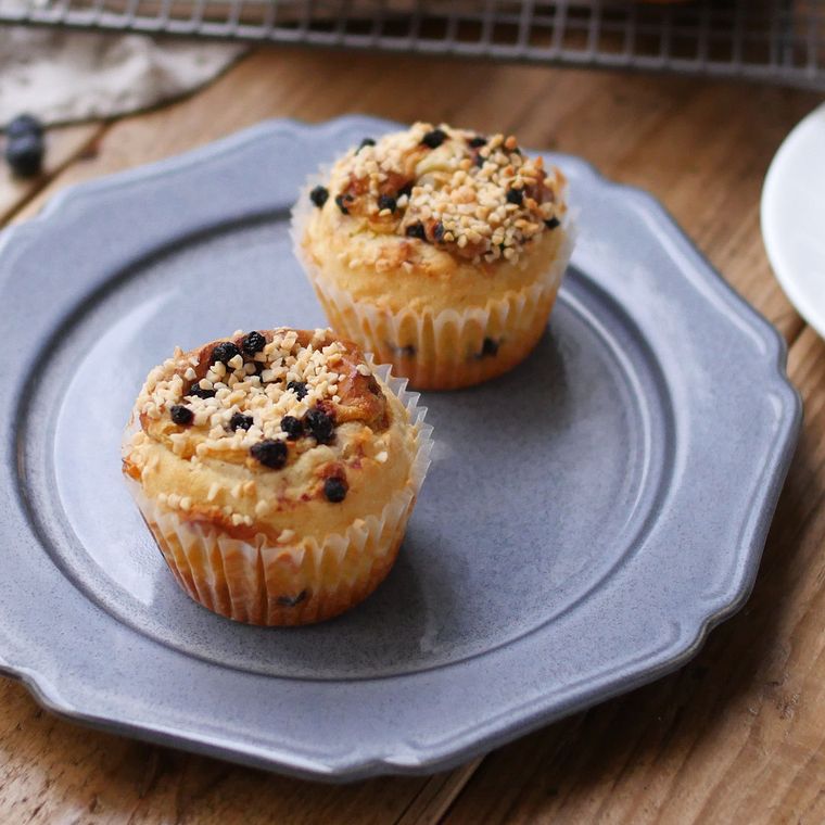 青い皿に盛られた、ブルーベリーカスタードのマフィン2個