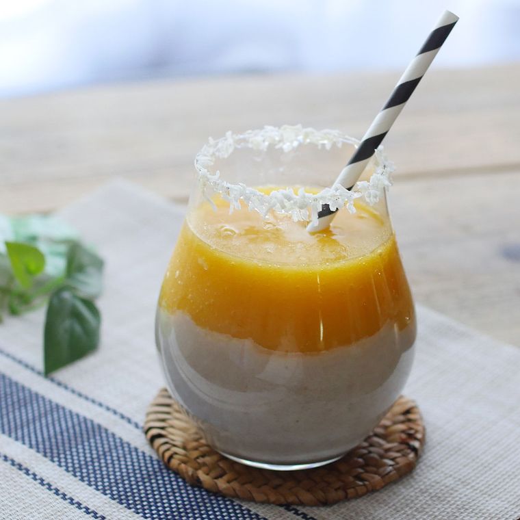 グラスに入れてストローをさした、マンゴーココナッツバナナスムージー