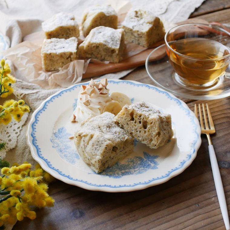 カットして皿に盛りクリームを添えた、紅茶のバナナケーキ
