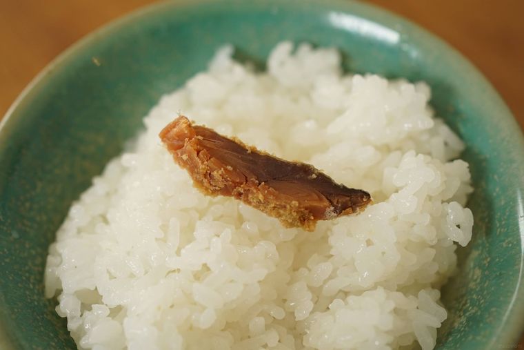 へしこをごはんにのせている